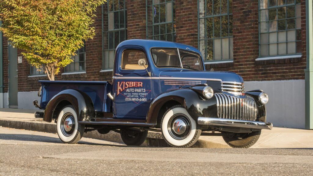 Papel de parede de uma picape Chevrolet clássica de 1946, restaurada nas cores azul e preta e pneus de faixa branca.