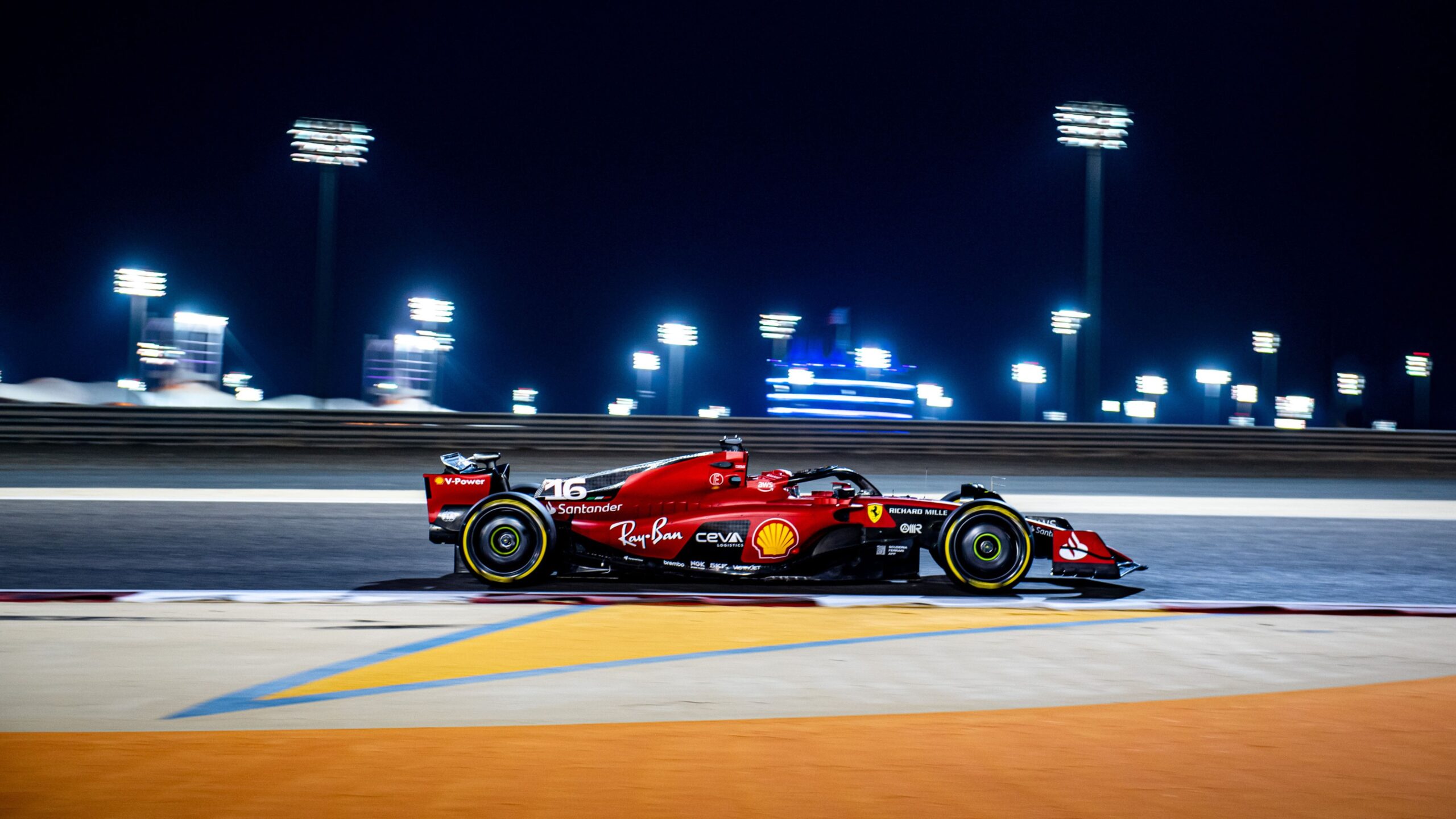 Ferrari SF-23 F1 (Charles Leclerc) Papel de parede do carro de Fórmula 1 Ferrari SF-23, número 16 (Charles Leclerc), correndo em alta velocidade no circuito do Bahrain à noite, com os refletores ao fundo.
